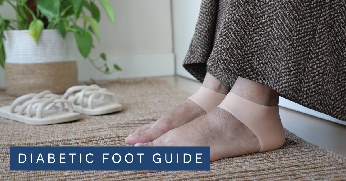 Bare feet resting on a rug beside a bed with a pair of slippers waiting on the floor